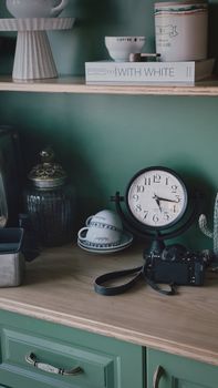 Stylish kitchen shelf with vintage clock, decor pieces, and camera.