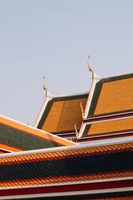 Close-up of the intricate rooftops at the Grand Palace in Bangkok, featuring vibrant colors and traditional architecture.