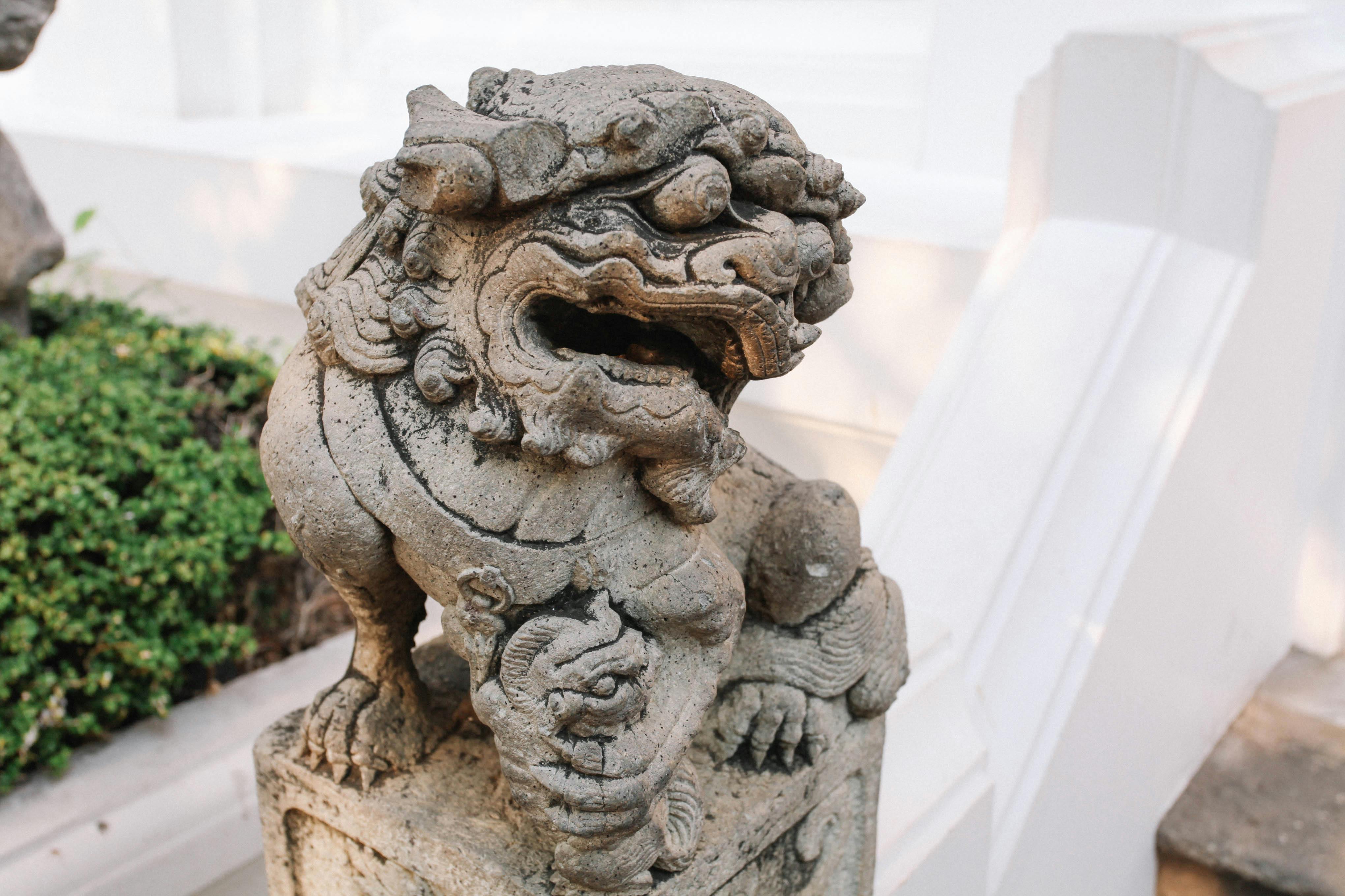 Close-up of an intricate stone lion sculpture at a temple in Bangkok, Thailand. - Colabora Birmania