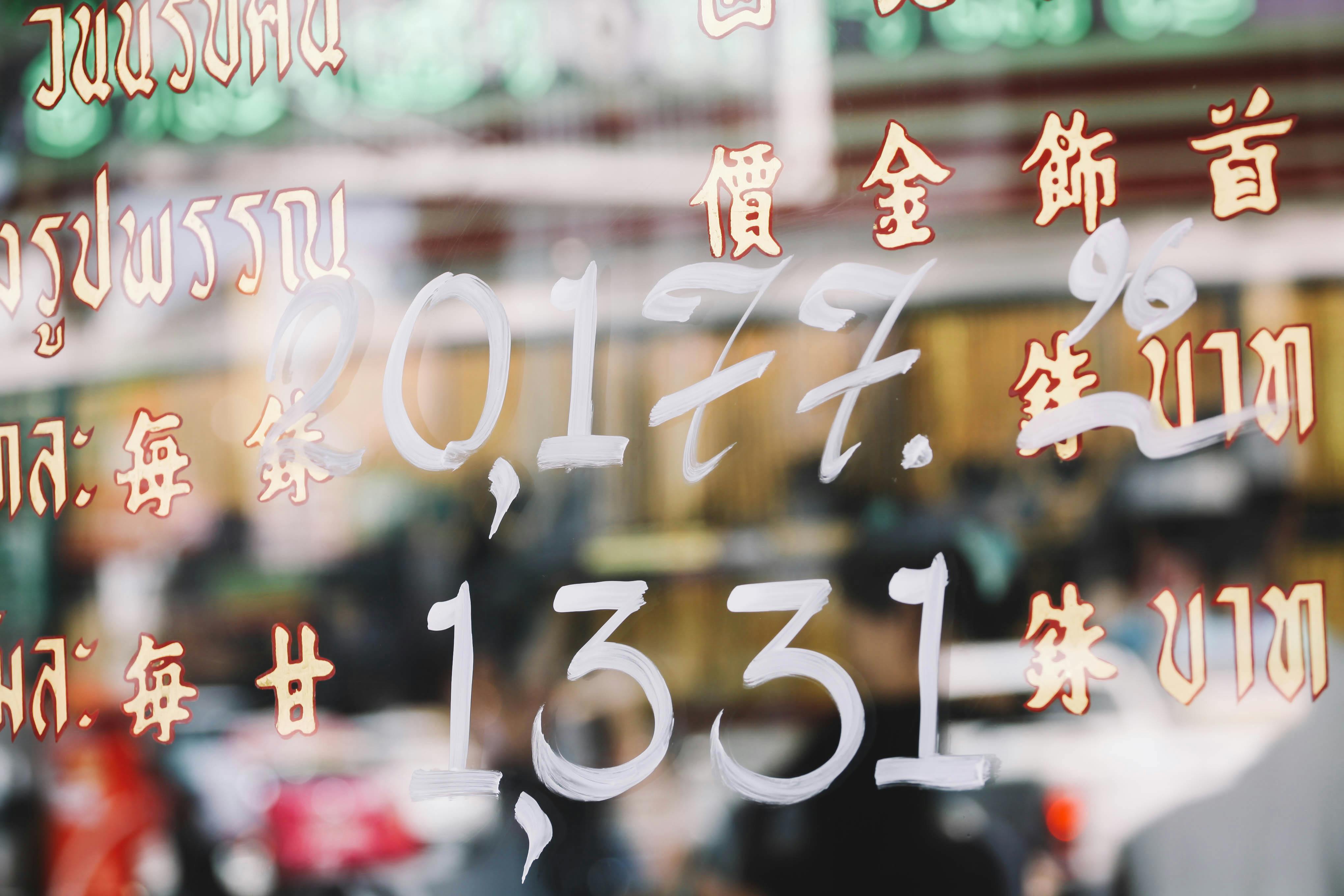 Colorful street reflections with Asian scripts in a bustling Bangkok market. - Colabora Birmania