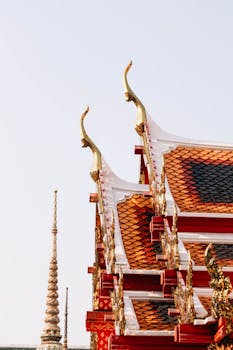 Intricate details of Thai architecture at The Grand Palace in Bangkok, showcasing vibrant colors and traditional design.