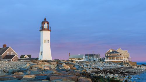 Free A picturesque view of Scituate Lighthouse against a sunset sky in Massachusetts. Stock Photo