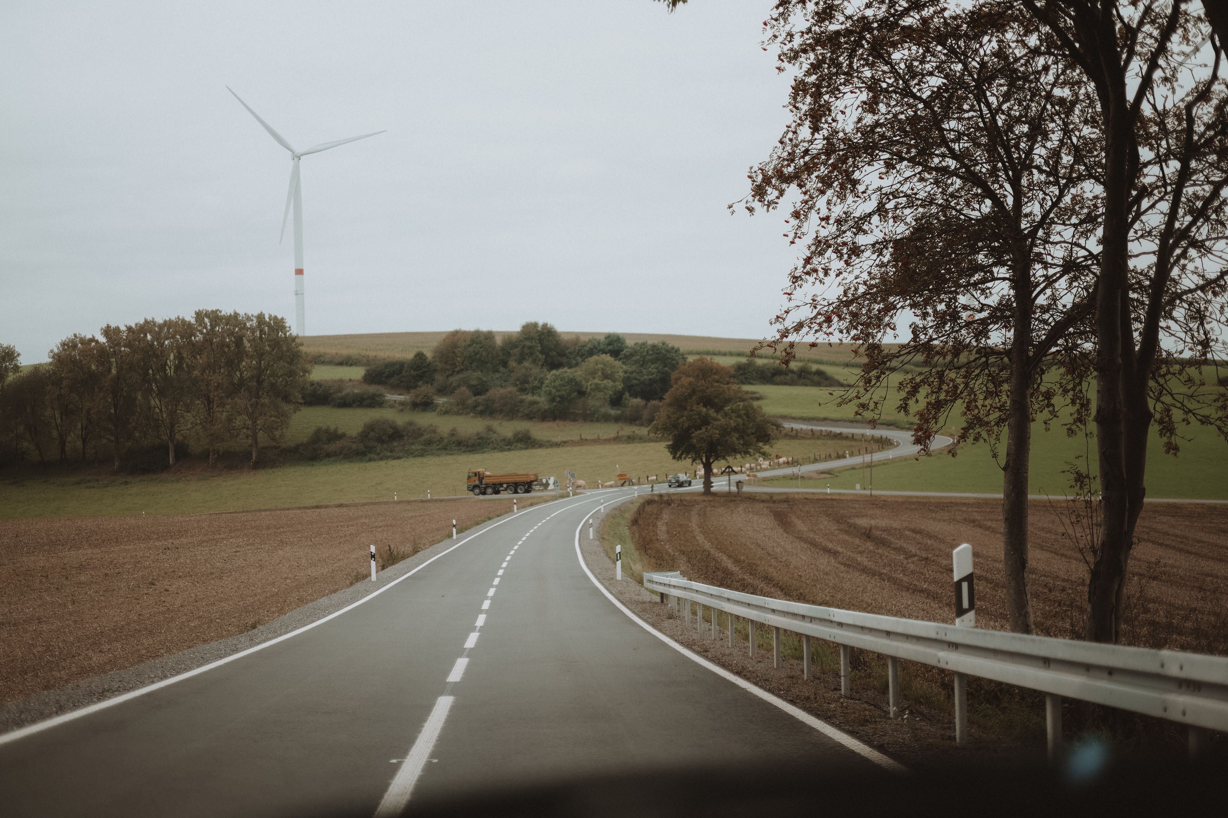 Scenic Autumn Road in Rural Germany with Wind Turbine · Free Stock Photo