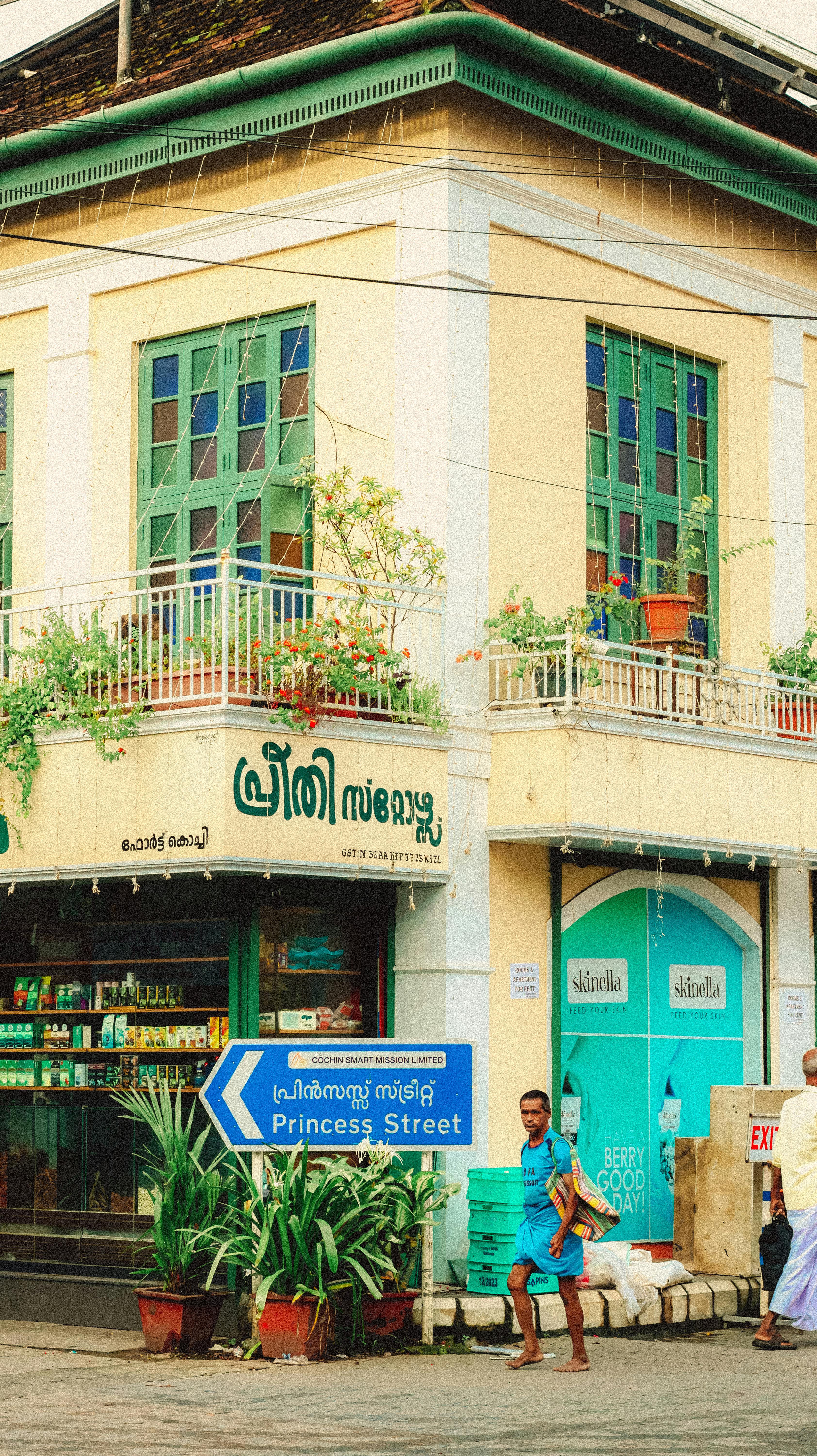 Vibrant street corner on Princess Street with a local shop and lush greenery.