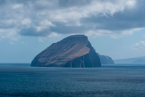 Free A breathtaking view of the sea cliff in the Faroe Islands under a cloudy sky. Stock Photo