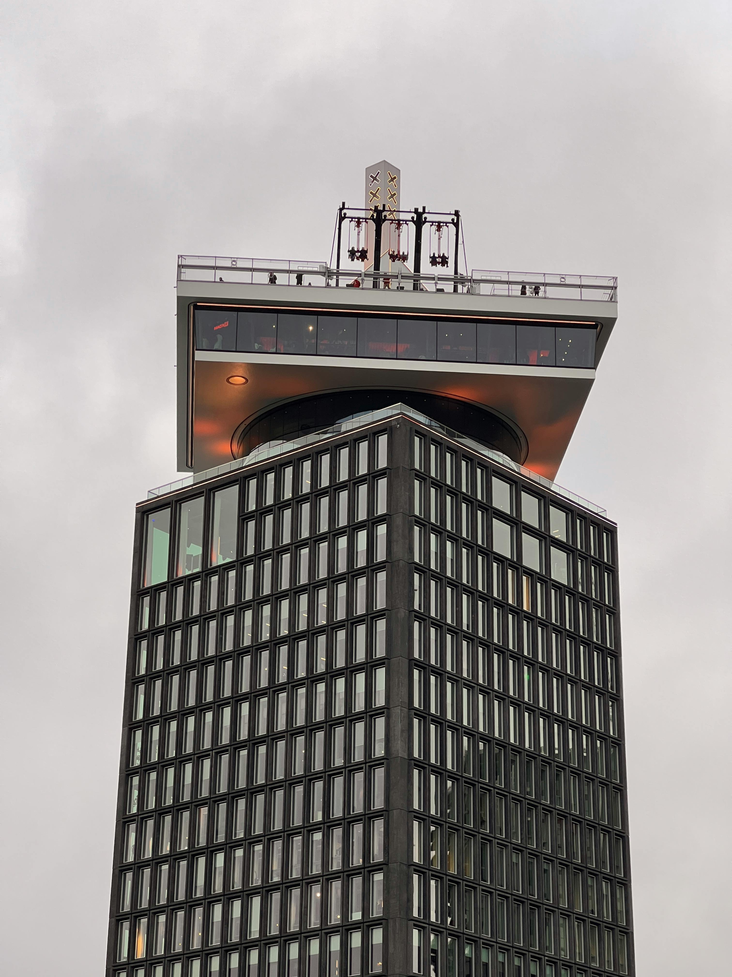 bezplatná Pohled na ikonickou věž A'DAM v Amsterdamu s pozadím zatažené oblohy, představující moderní architekturu. Základová fotografie