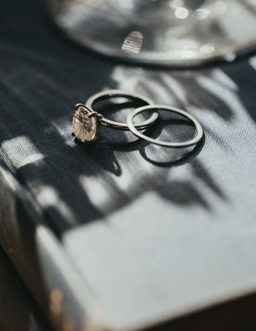 Free Close-up of elegant engagement rings on a vintage book with champagne glass background. Stock Photo