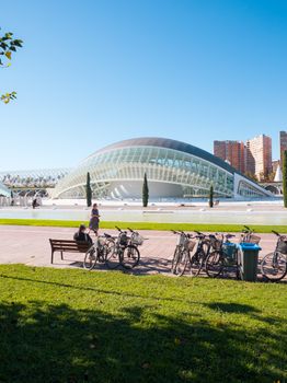 Cyclists enjoy sunny day at futuristic architecture in Valencia, Spain.