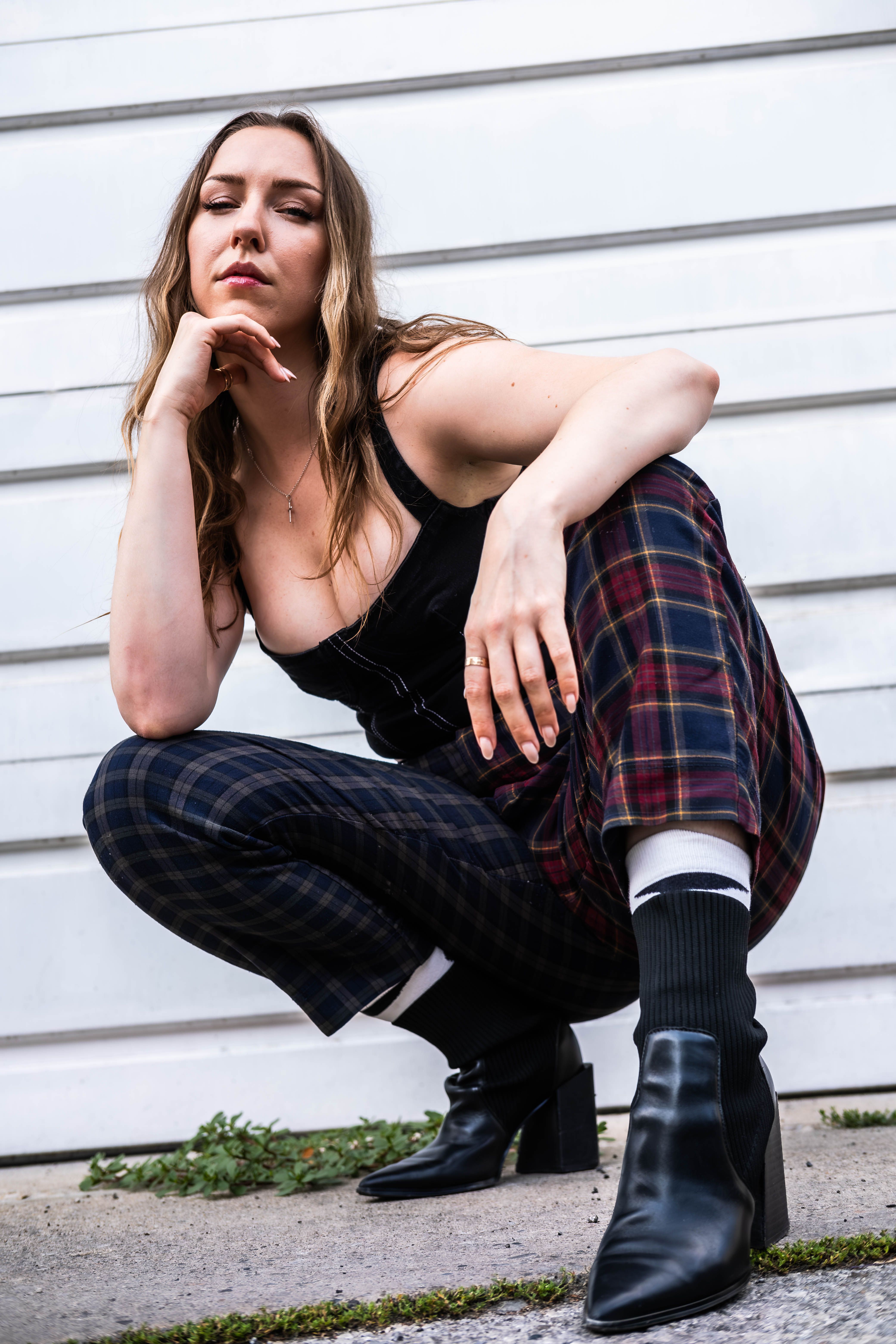 Woman posing in plaid pants against urban backdrop in Toronto.
