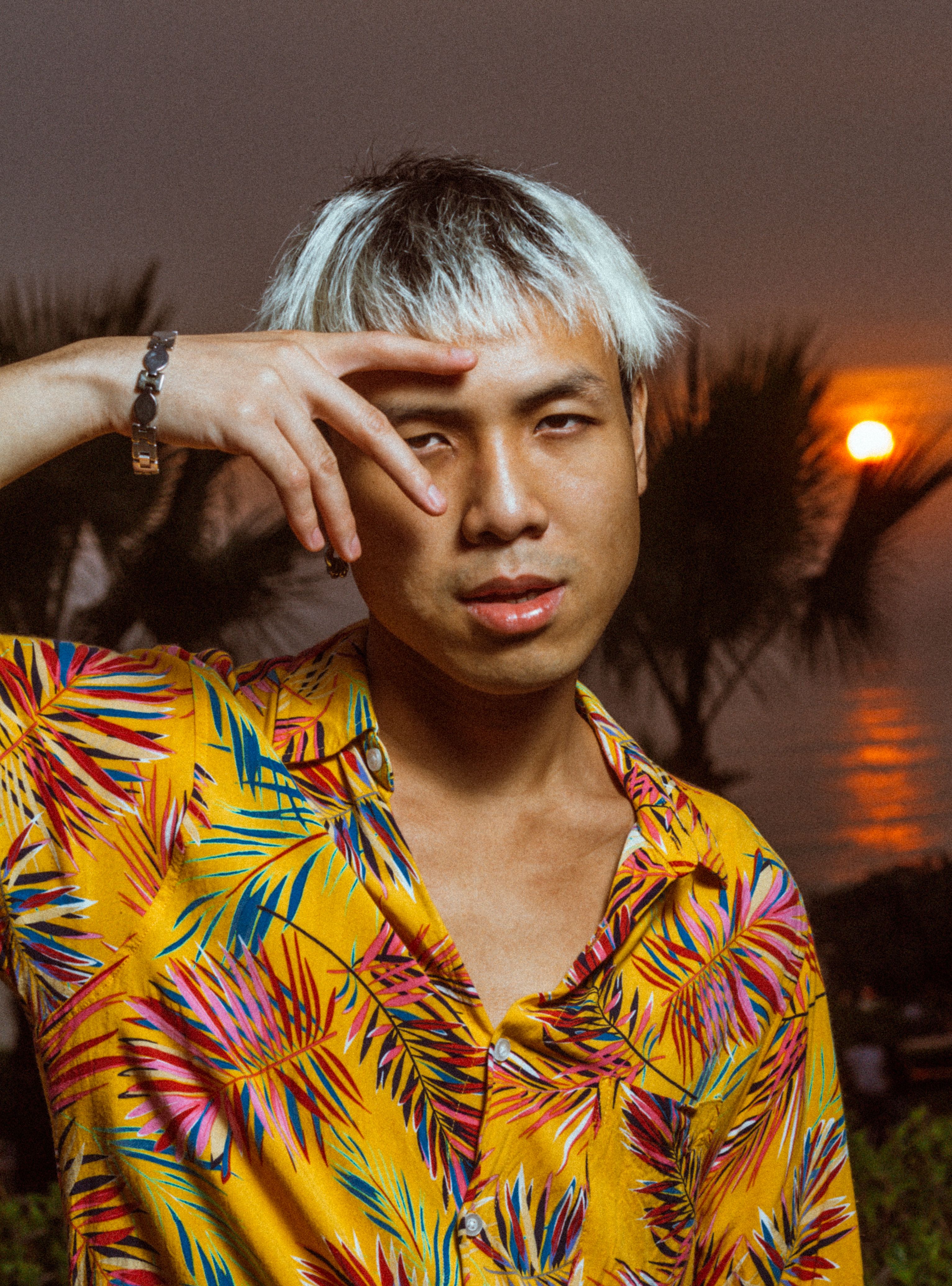 Vibrant portrait of a person in a tropical shirt at sunset on the beach.