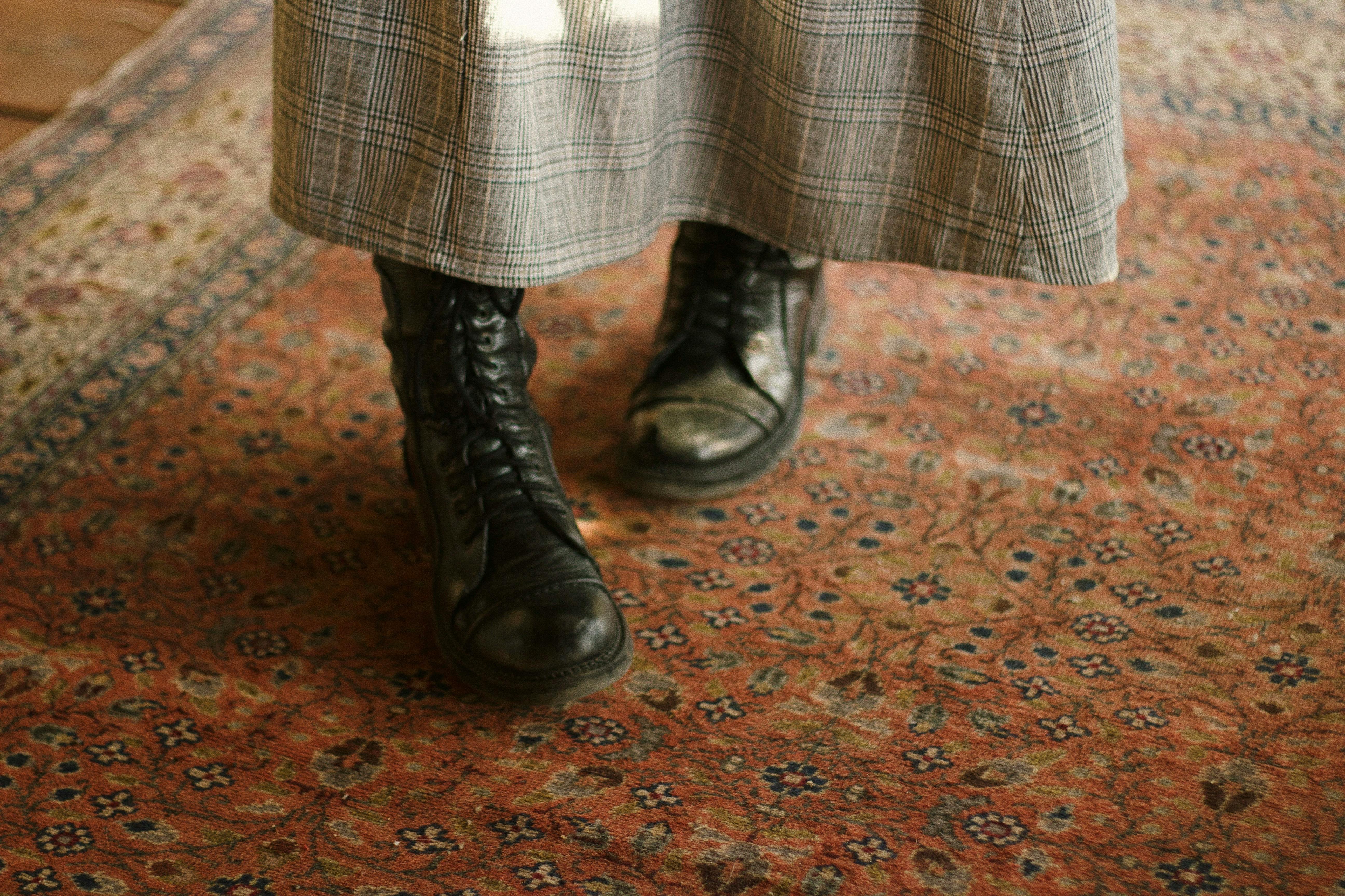 Close-up of vintage combat boots on an intricate Persian rug for a cozy, rustic feel.