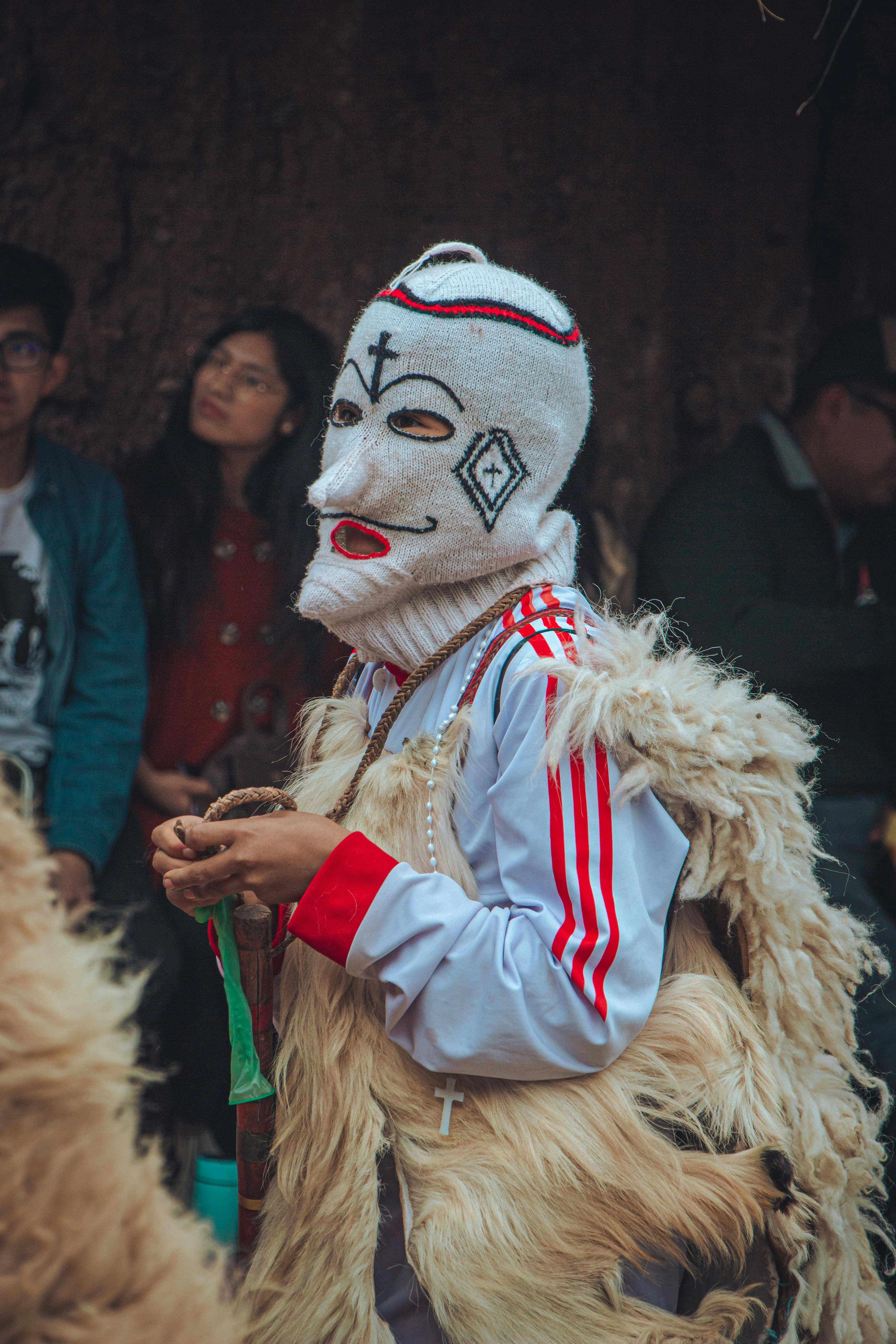 Cultural festivity with masked dancer in traditional attire, San Salvador, Peru.