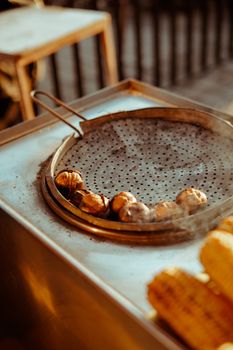 Grilled chestnuts on a street vendor tray, exuding rustic warmth and flavors.