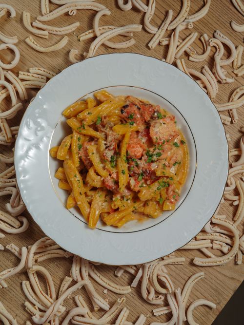 Free Close-up of penne pasta with creamy tomato sauce garnished with herbs. Stock Photo
