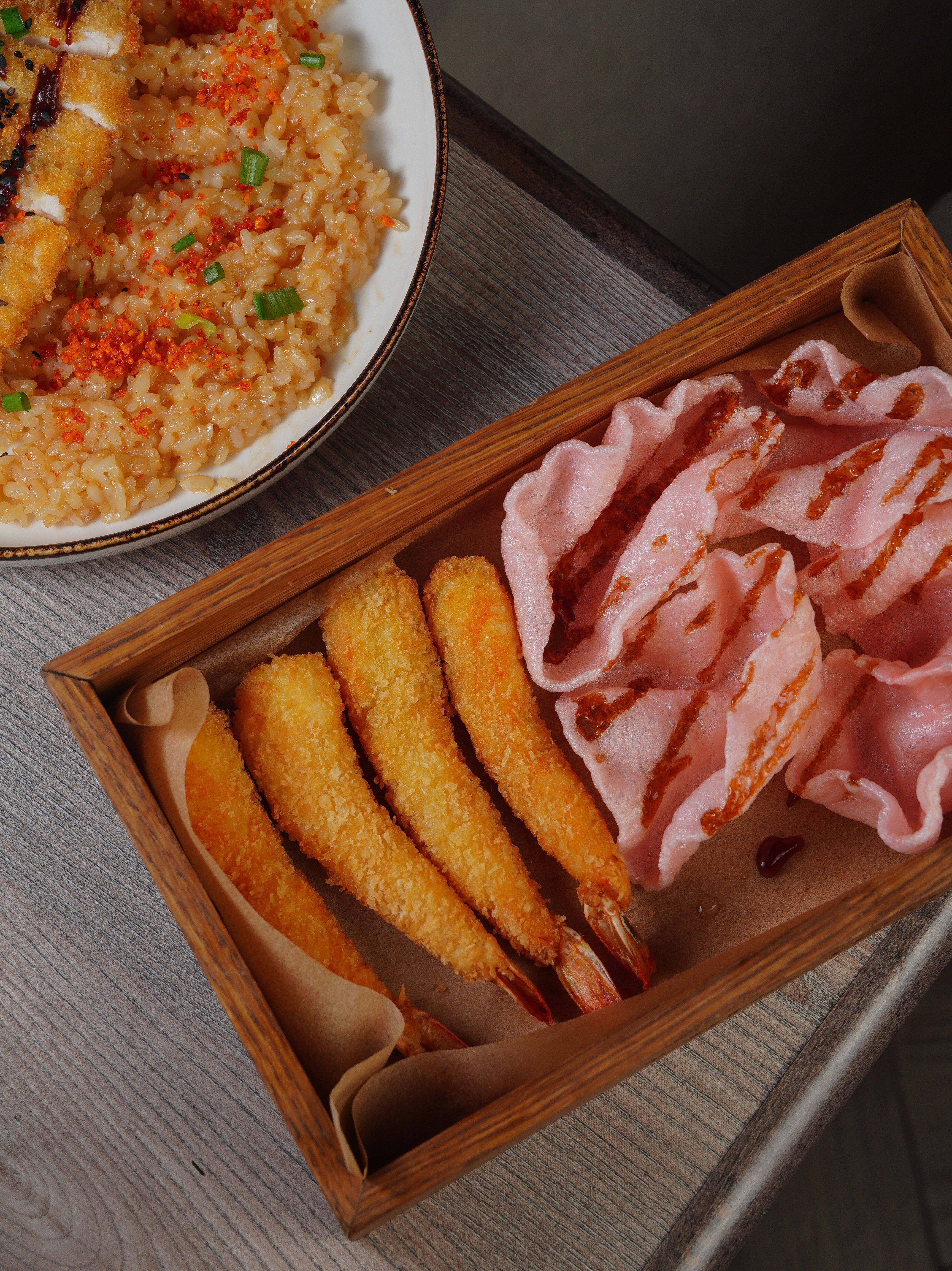 A delicious top view of crispy fried shrimp with rice and shrimp crackers.