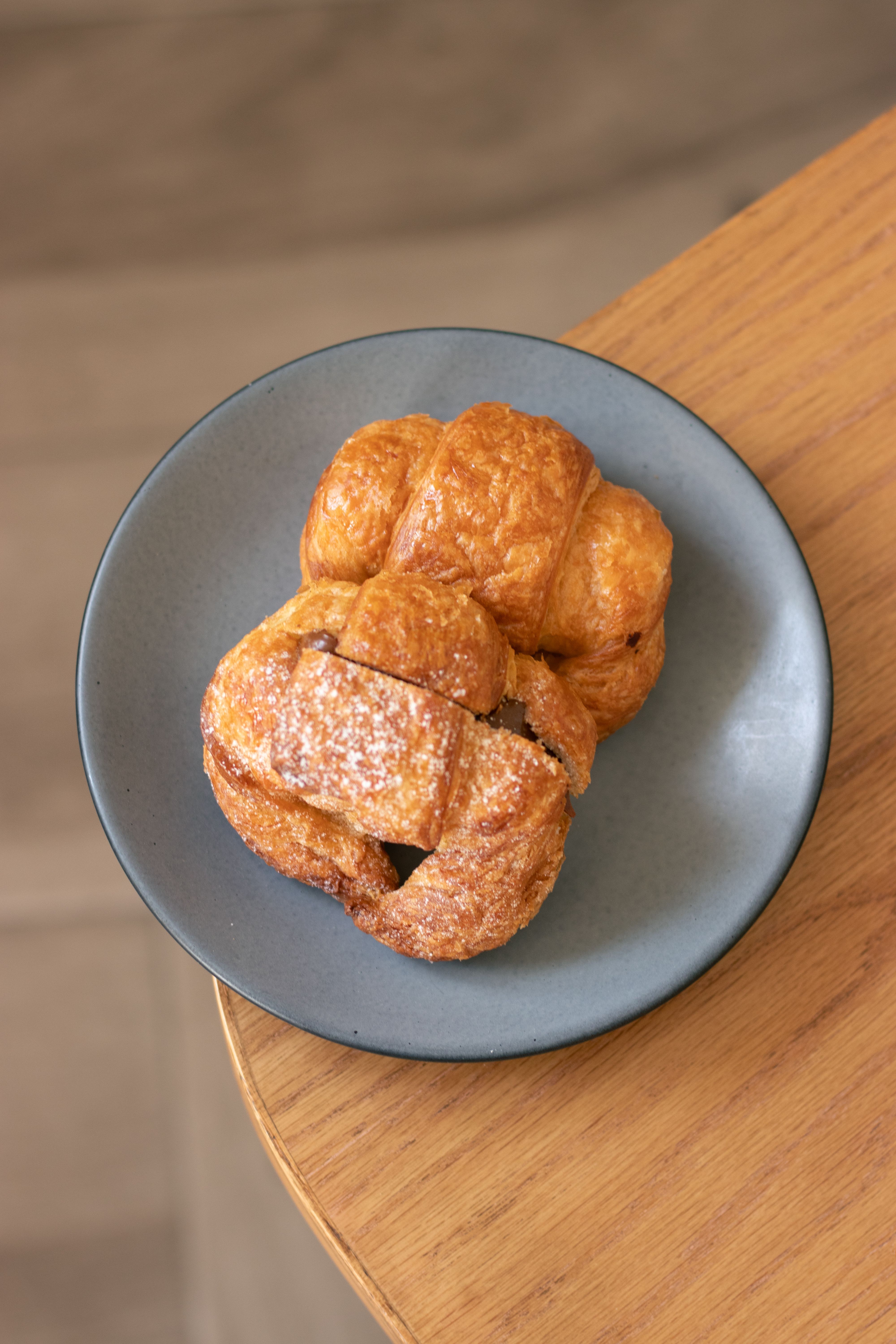 Golden croissants stacked on a grey stoneware plate