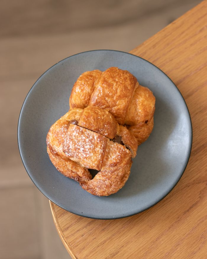 Golden croissants stacked on a grey stoneware plate