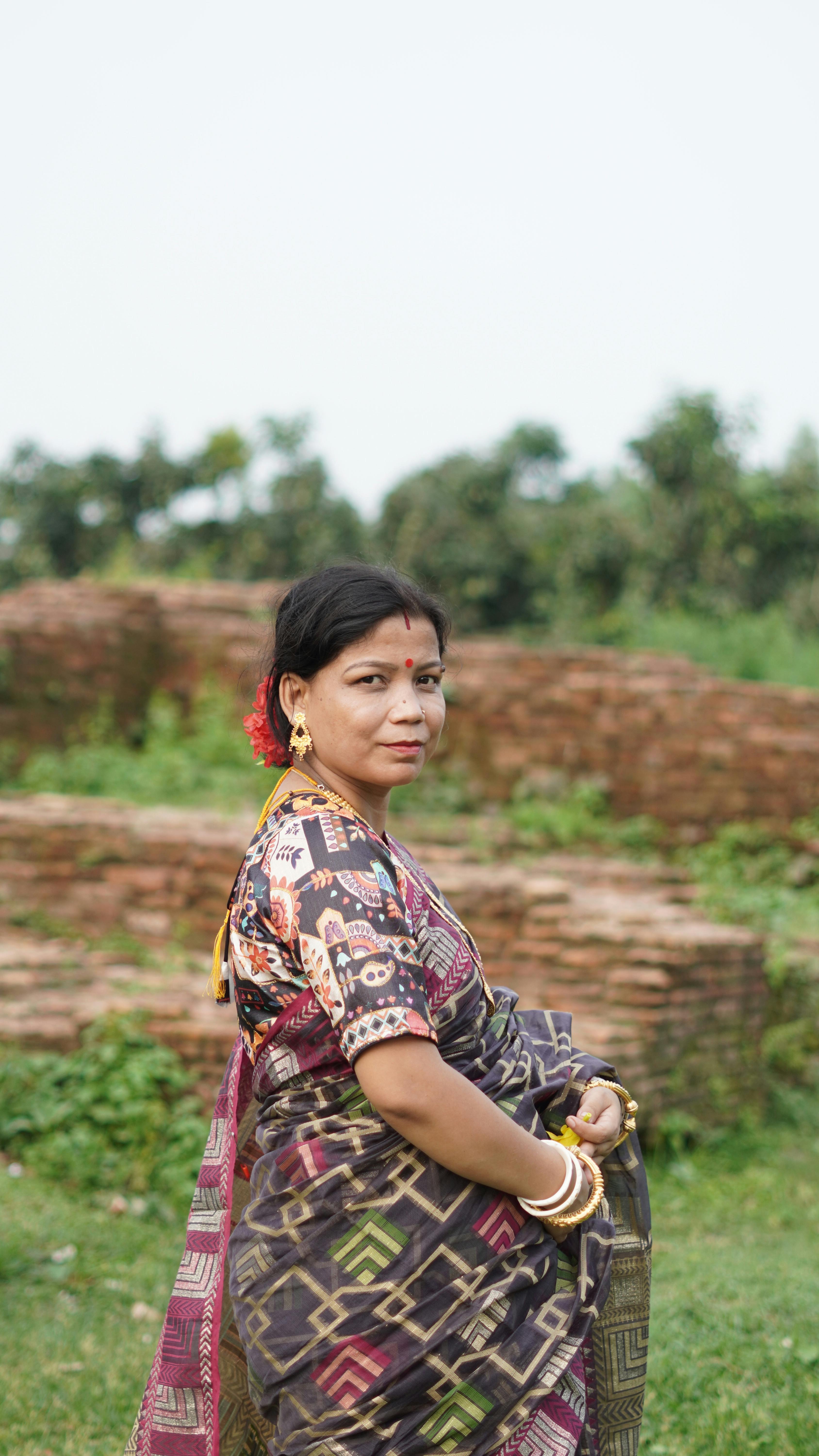 Portrait of a South Asian woman in traditional attire, with a serene natural backdrop in Dinajpur, Bangladesh.
