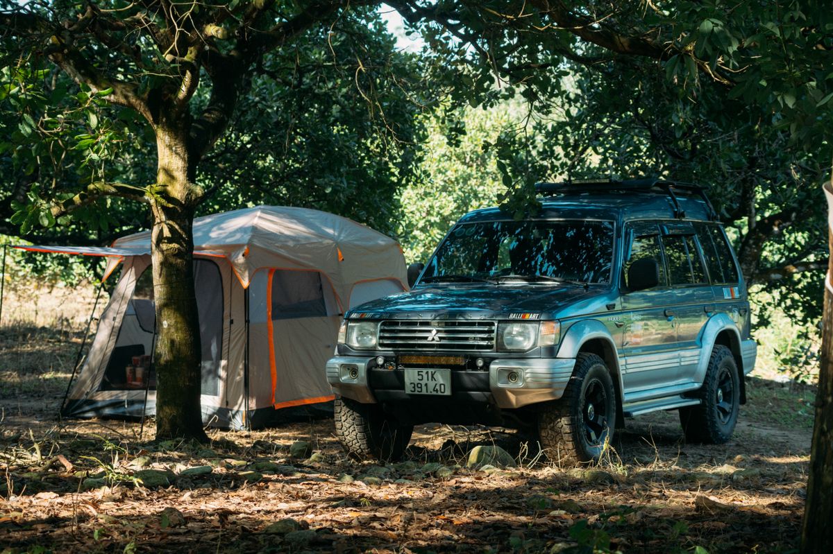 Off-road SUV and tent set up at an established forest campsite