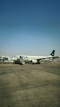A PIA Airbus parked at Karachi Airport showcasing aviation and travel infrastructure.