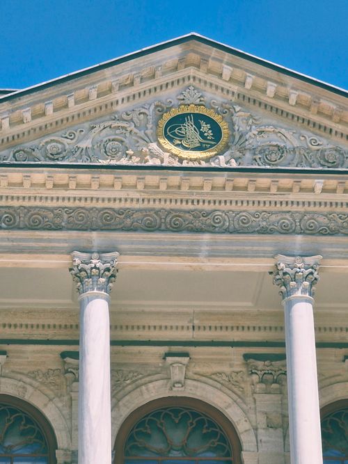 Free Detailed view of a historic building facade featuring intricate carvings and prominent columns. Stock Photo