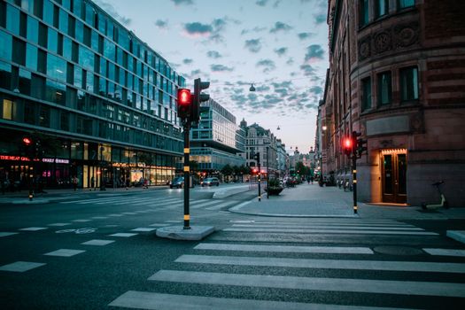 A serene view of a city street intersection at twilight with traffic signals and modern architecture.