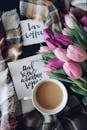 这杯温暖诱人的咖啡，配有郁金香和书法卡片，非常适合舒适的早晨