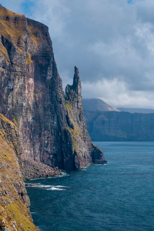 Free Majestic cliffs and sea stacks on the Faroe Islands under a cloudy sky. Stock Photo