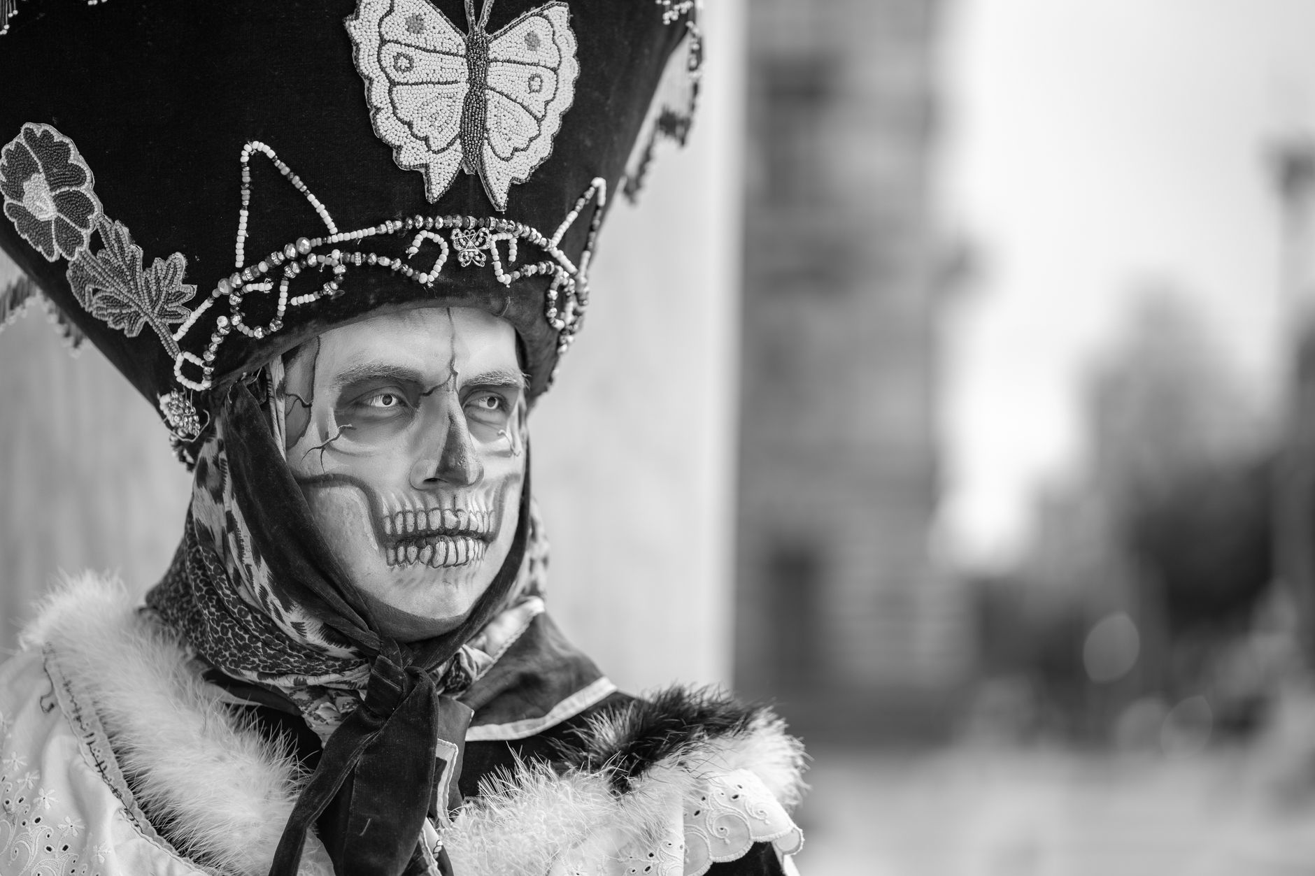 Black and white portrait of a person in Catrina costume and makeup, showcasing Mexican cultural traditions.