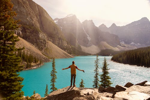 Um Homem Parado Na Falésia Sobre Um Lago