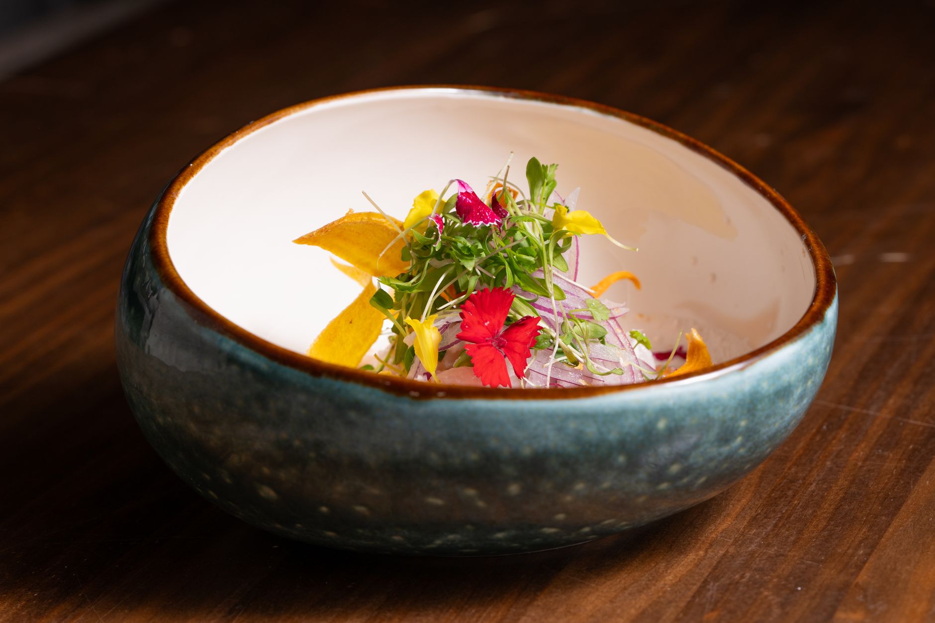 Why do chefs use microgreens and edible flowers for garnishing plates?