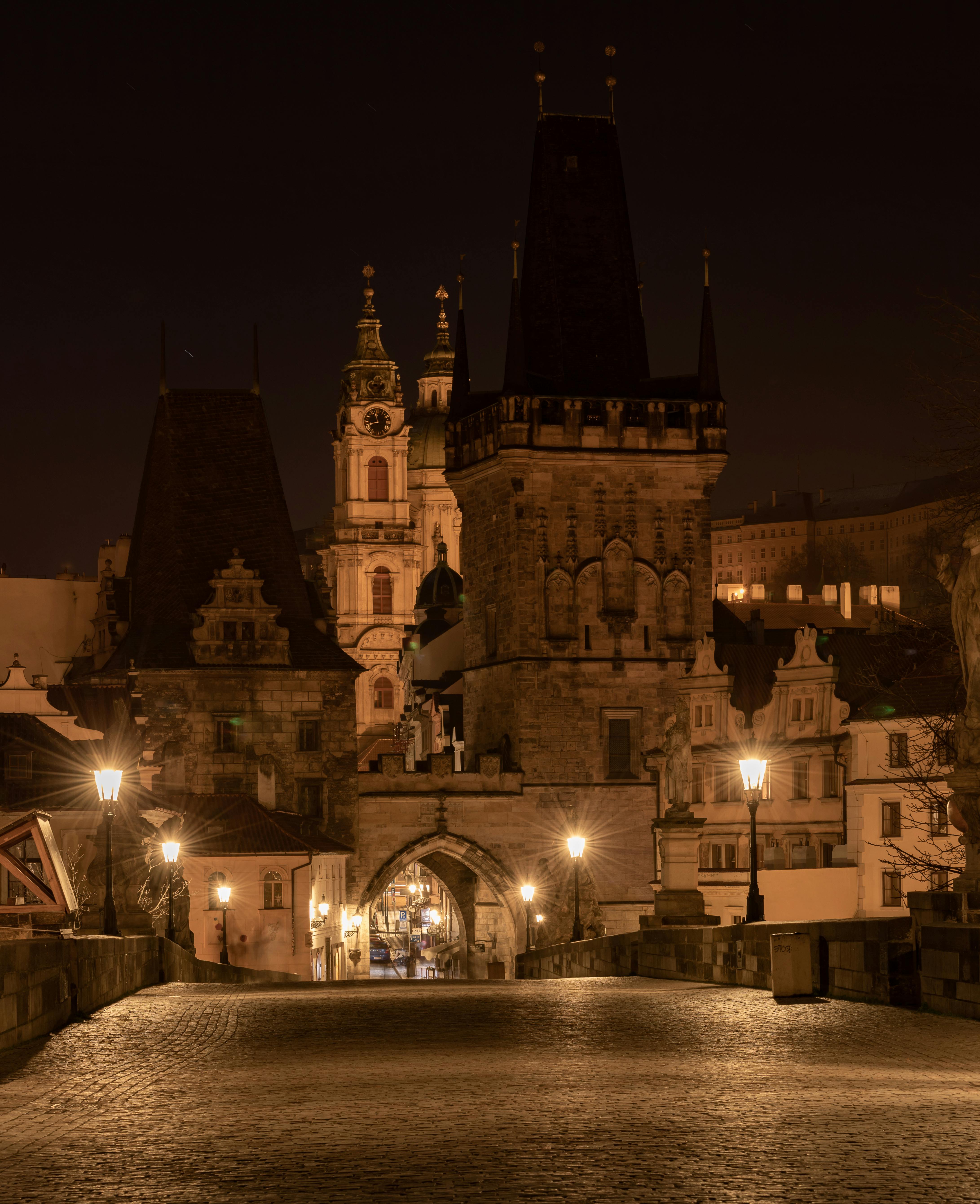 A serene night view of Charles Bridge and Old Town Prague, brilliantly illuminated.