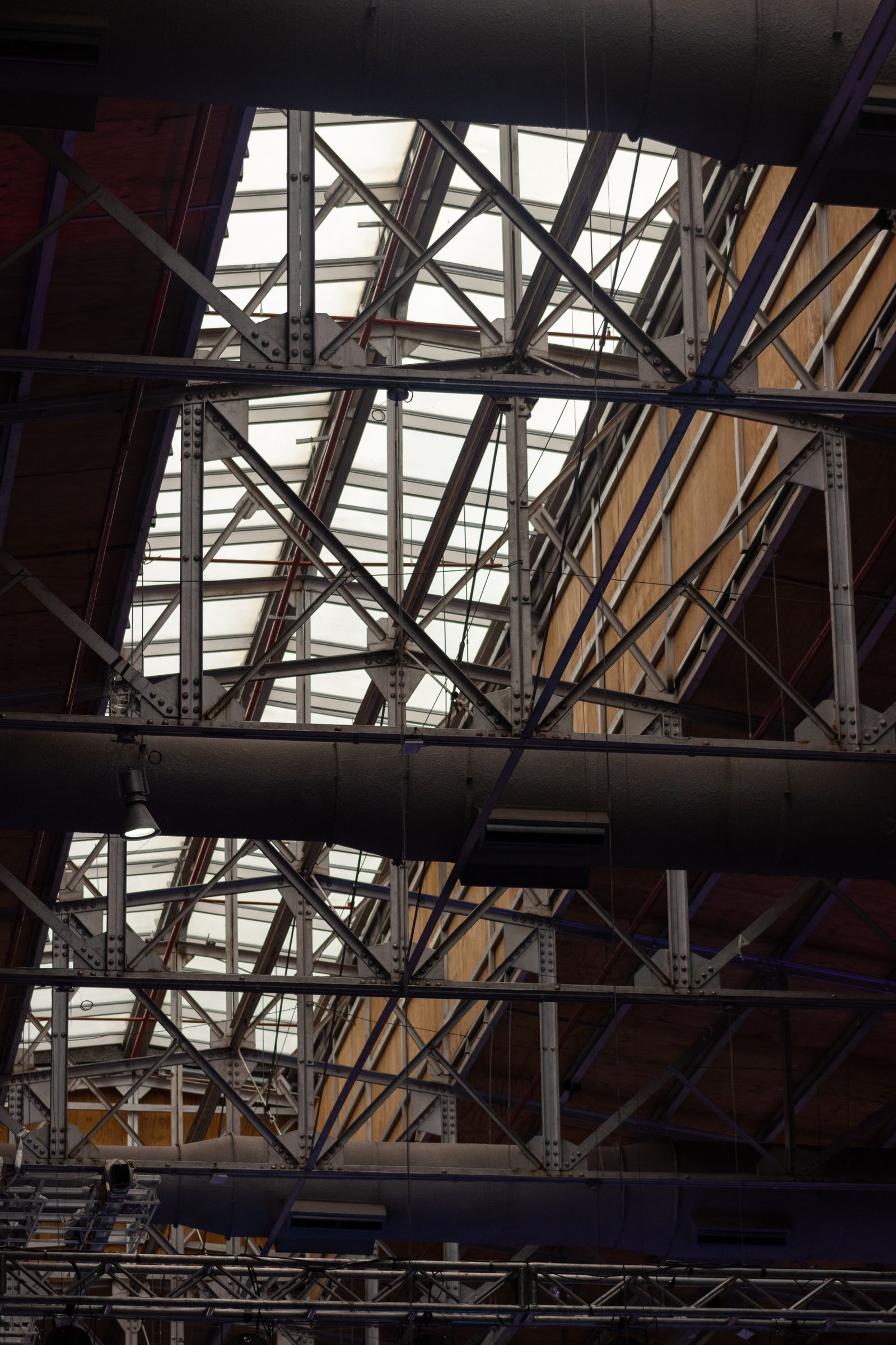 Dark steel roof trusses and bracing inside an industrial building under construction