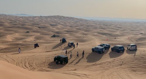 Free A group of SUVs and people explore the sand dunes in Sharjah, UAE. Stock Photo