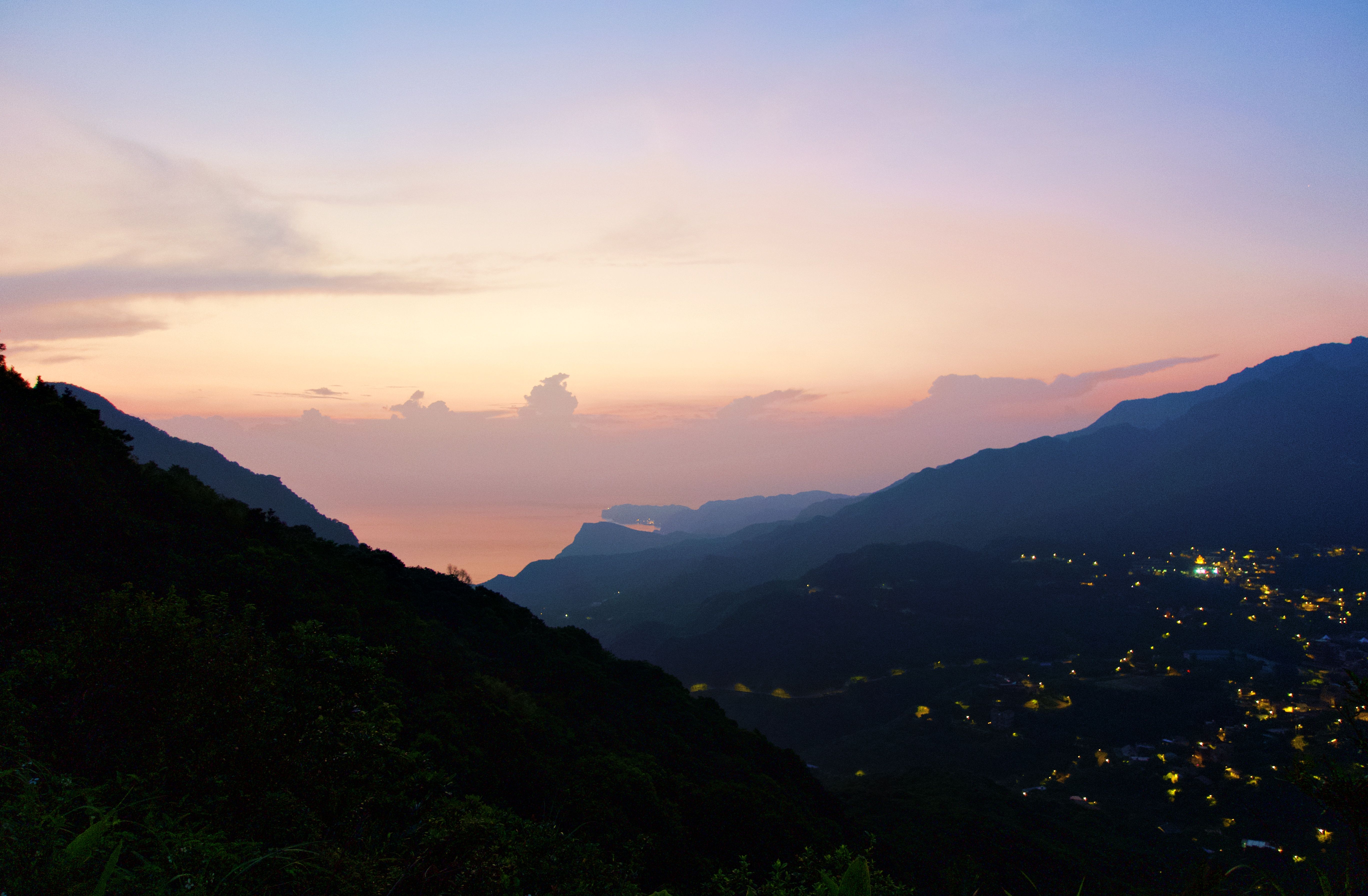 Gorgeous sunset view over the mountains and city lights of New Taipei City, Taiwan.