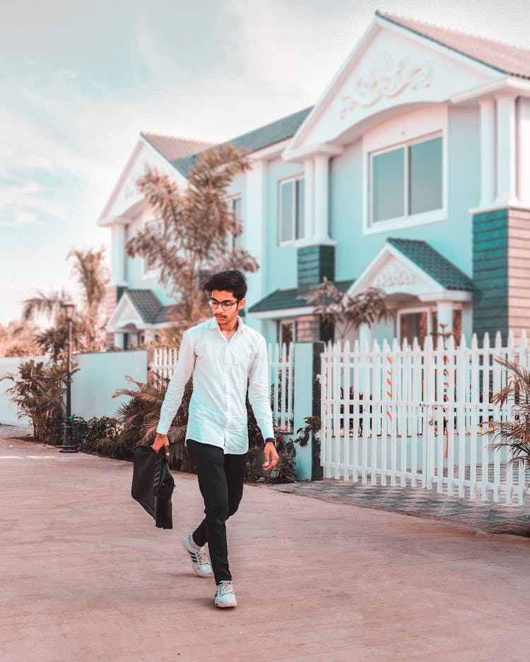 Man Wearing White Dress Shirt Walks On The Street