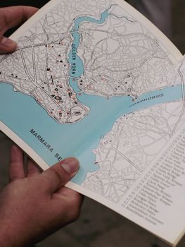 Close-up of hands holding a map showing Istanbul and the Bosphorus.