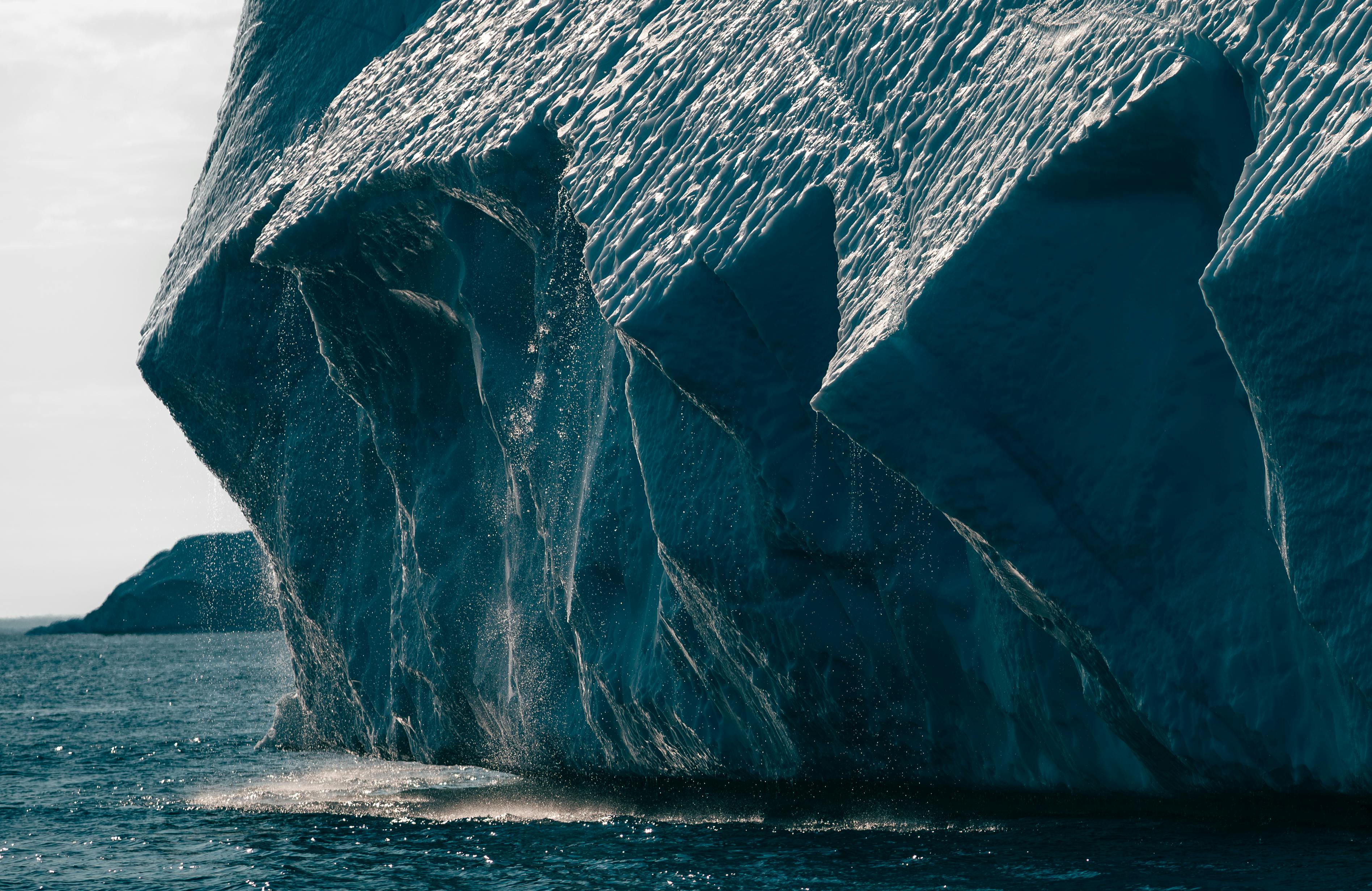 Dramatic close-up view of a melting iceberg in the Arctic ocean, showcasing climate change effects.
