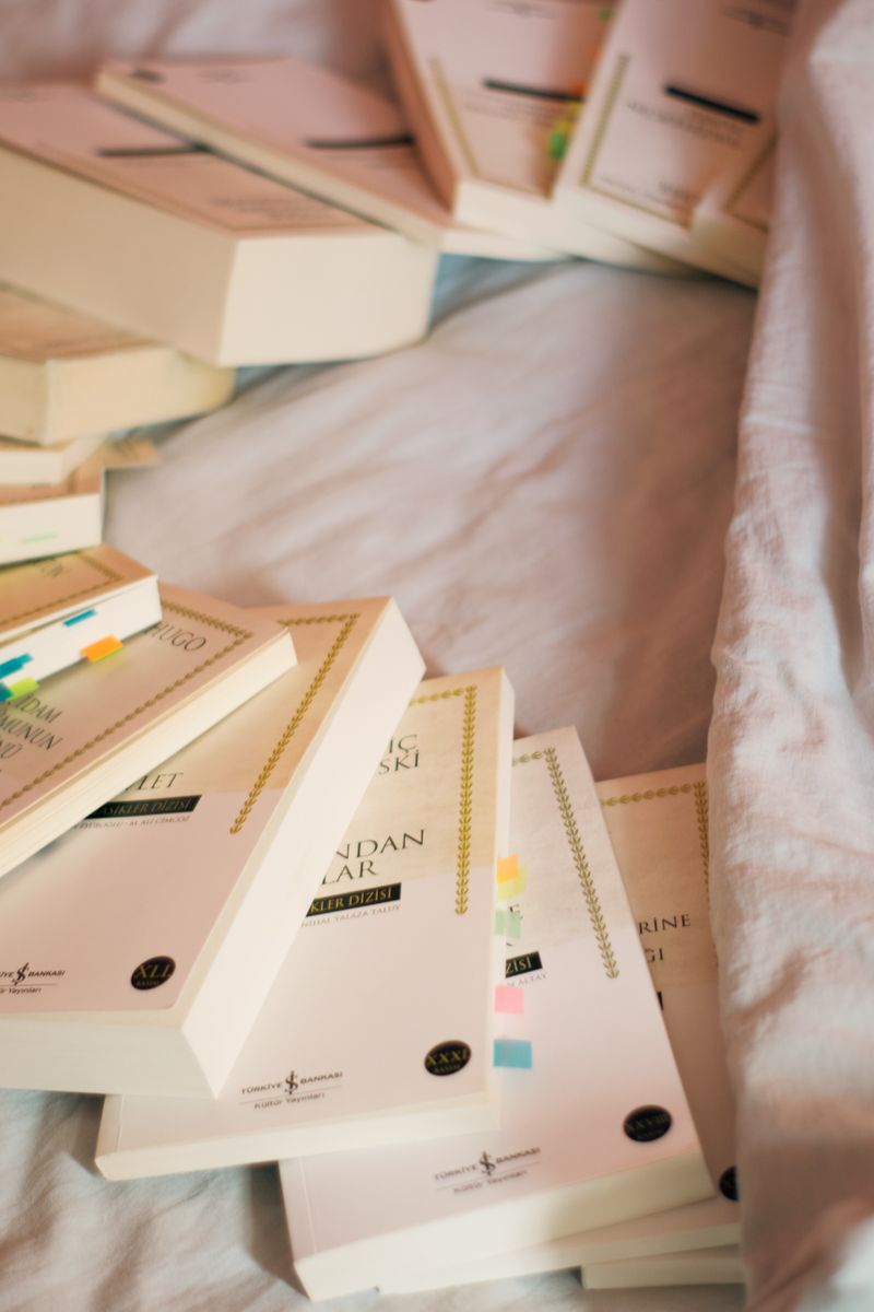 A cozy scene of books with colorful tabs on a bed, suggesting learning or study. A cozy scene of books with colorful tabs on a bed, suggesting learning or study.