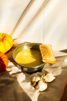Delicious pumpkin soup with garlic bread, perfect for autumn evenings.