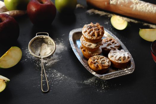 Delicious homemade mini apple pies dusted with sugar, perfect for a cozy dessert.