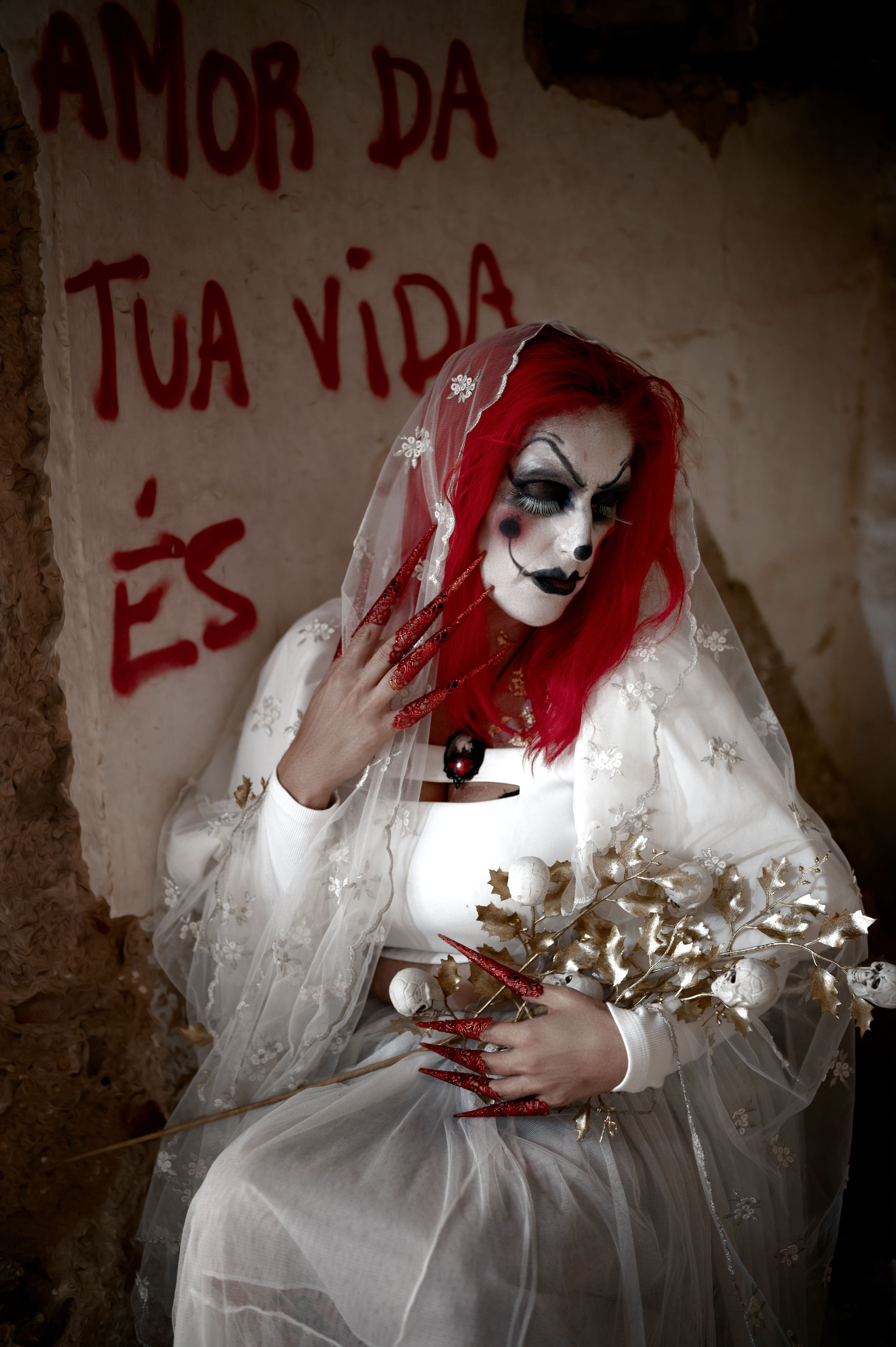 Red-haired bride with gothic makeup holding flowers in Lisbon. Mysterious and dramatic scene.