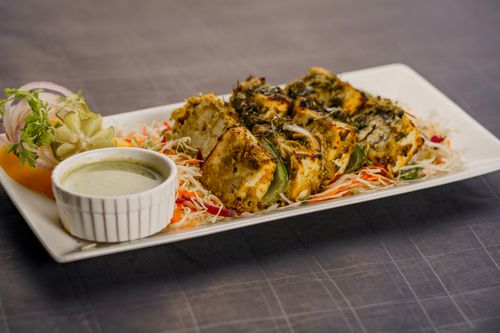 Free Succulent herb-crusted paneer tikka served with chutney and salad on a stylish plate. Stock Photo