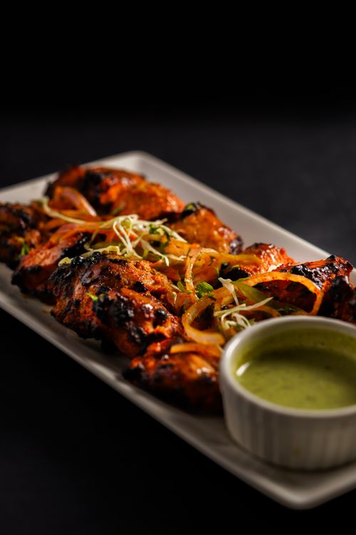 Free Juicy grilled chicken tandoori served with fresh mint chutney and herbs. Stock Photo