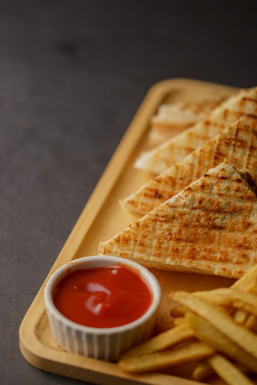 Free Delicious grilled sandwich with fries and ketchup on a wooden tray, perfect snack. Stock Photo
