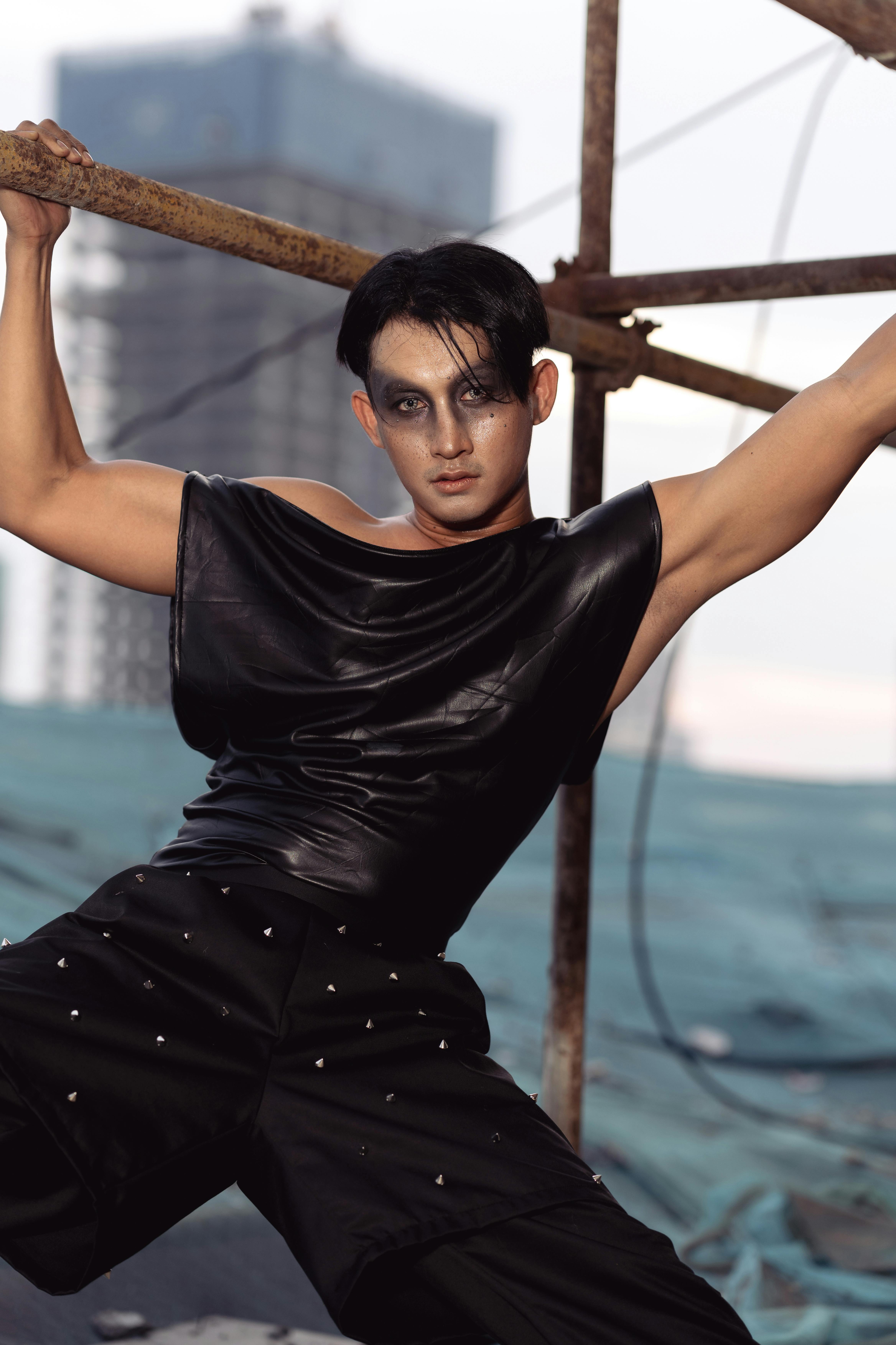 Gratis Pemotretan mode perkotaan yang dinamis menampilkan seorang model berpakaian hitam. Foto Stok