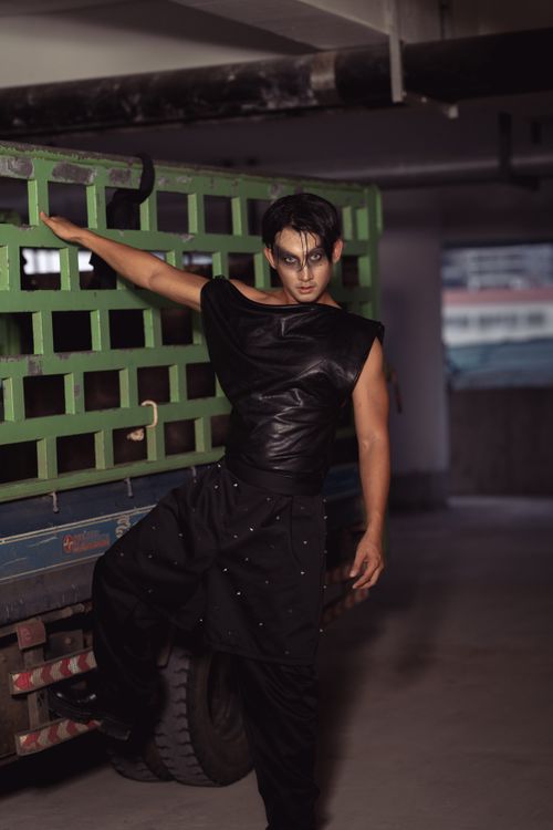 Free Stylish male model in black attire posing confidently by a truck. Stock Photo