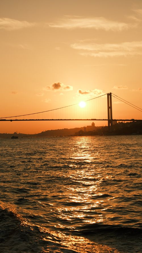 Free Sunset view of a stunning bridge over water, casting golden reflections. Stock Photo