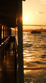 Silhouette of a ferry on the sea at golden sunset, reflecting tranquil beauty.