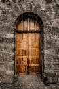一扇质朴的木门嵌在纹理丰富的石墙上，散发着古董的魅力和建筑趣味